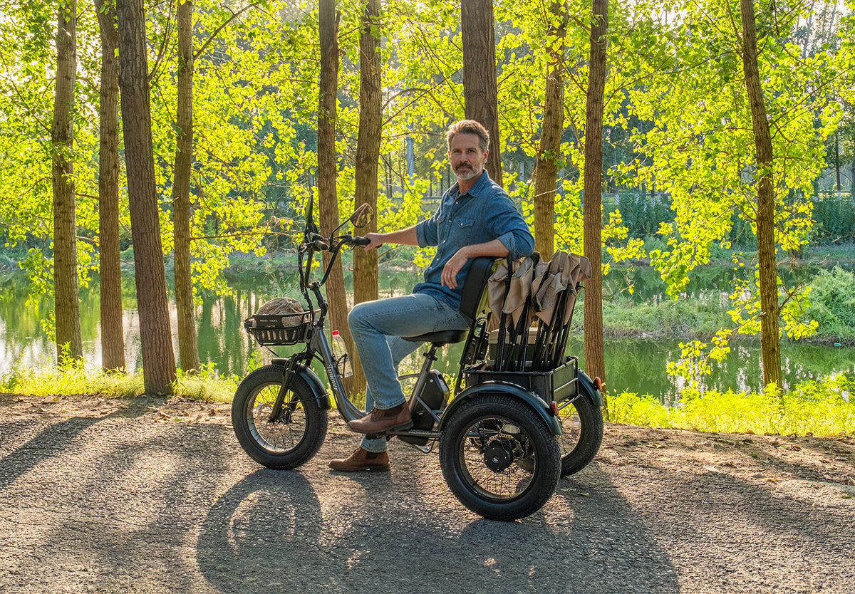 Tiniover Creek electric trike with an adult man rider in a wooded lakeside setting